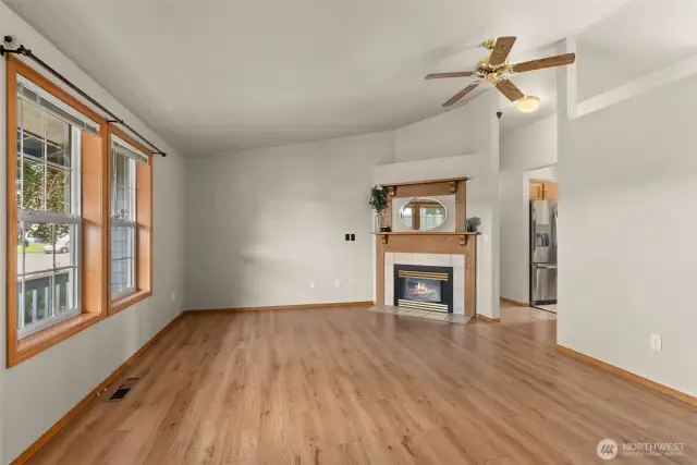 Living room with vaulted ceilings and electric fireplace.