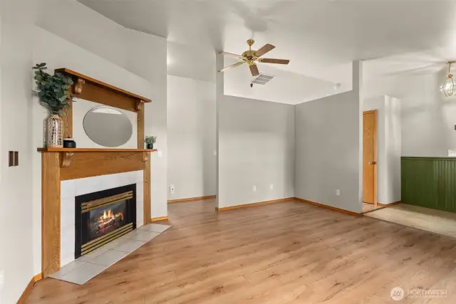 Living room with vaulted ceilings and electric fireplace.