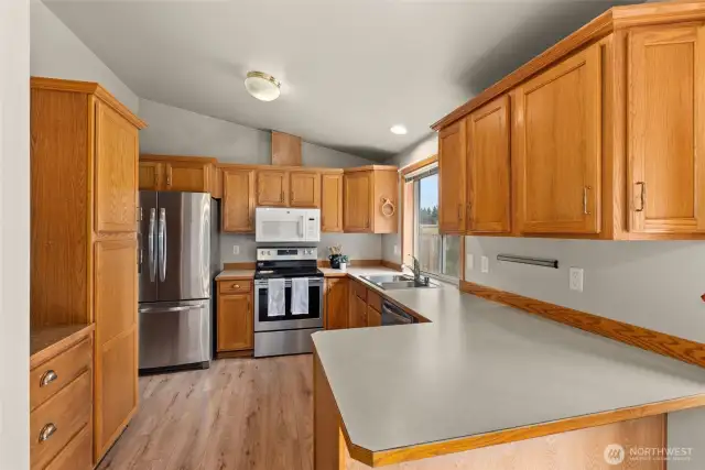 The kitchen features vaulted ceiling, lots of counter space, and stainless appliances.