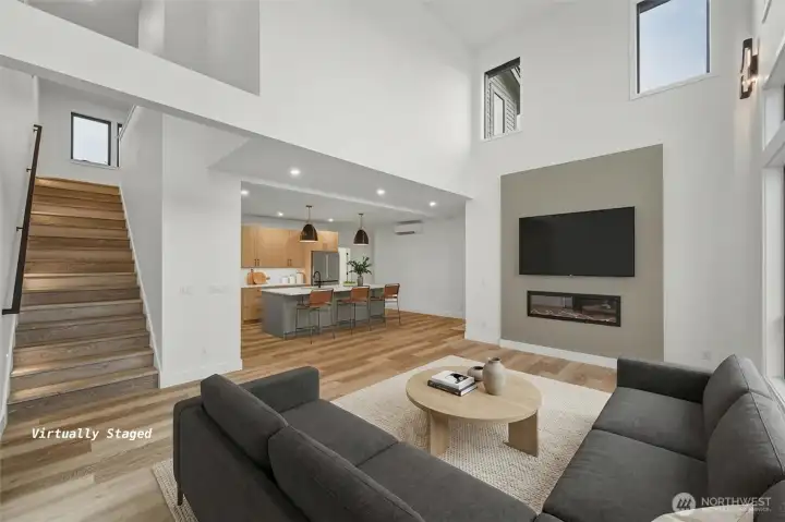 Another view of the living area and kitchen with stairs to the upper level.