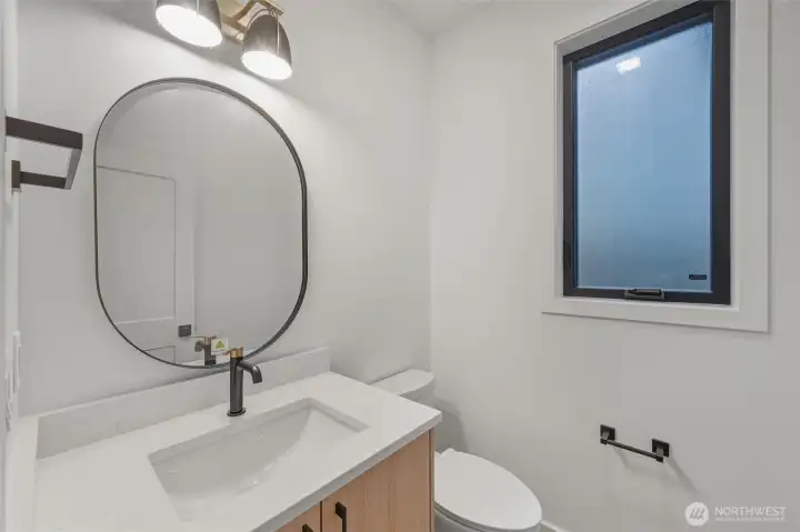 Main floor half bath, located just off of the kitchen area, near the garage.