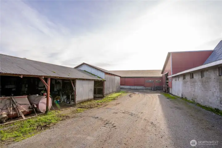 Picture of machine shed with the hay storage building, loafing barn straight ahead and parlor to the right