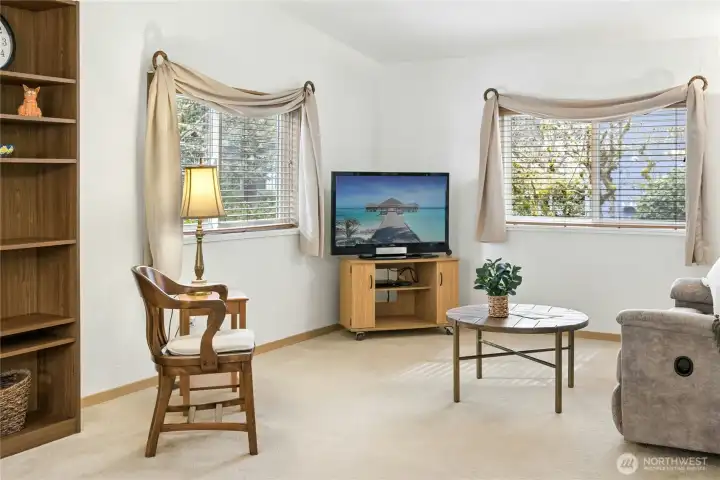 Great room is light and bright, with newer vinyl windows overlooking native pine greenbelt