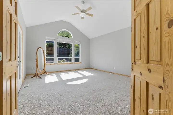 Primary bedroom with double wood doors.