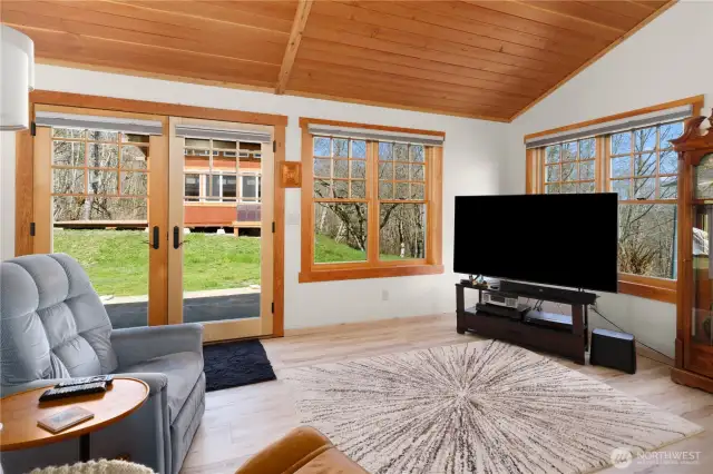 The den/tv room is light and bright with beautiful wood trim detailing and French door to the outdoors.