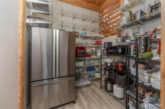 The pantry room has tons of storage space and a second refrigerator.