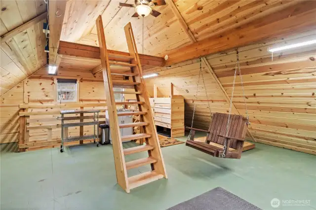 The upper garage level has a sink behind the ladder, windows, ceiling fan, storage space and is quite livable.