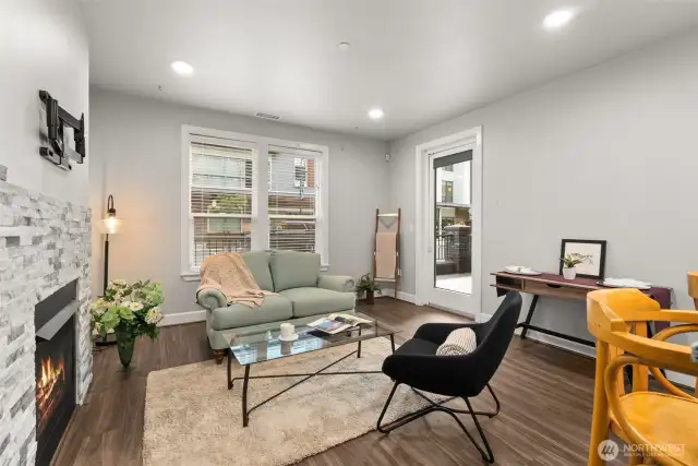 Inviting living room with cozy gas fireplace, newly installed vinyl flooring, and easy access to all that Point Ruston has to offer.