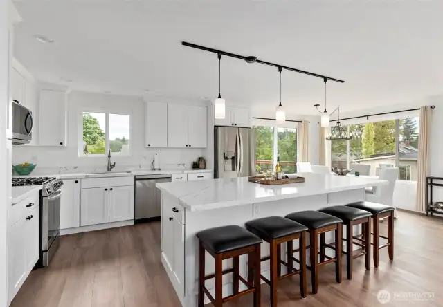 This spacious, fully remodeled kitchen is a true showstopper. It features all-new flooring, modern lighting, sleek quartz countertops, and a dual heat stove with a gas cooktop and electric oven—perfect for any home chef. With a new dishwasher, microwave, and an abundance of cabinetry, you'll have storage for days and style to match.