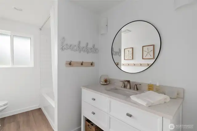 The guest bath has been fully remodeled and offers a fresh, modern feel with a beautiful vanity, updated flooring, stylish lighting, and a sleek tub/shower combination—designed for both comfort and elegance.