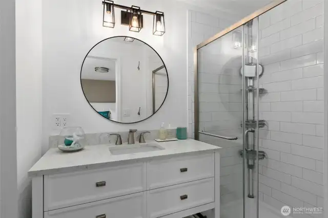 The primary bathroom has been completely updated with all-new flooring, a sleek shower, modern vanity, toilet, and stylish lighting—offering a fresh, contemporary feel from top to bottom.