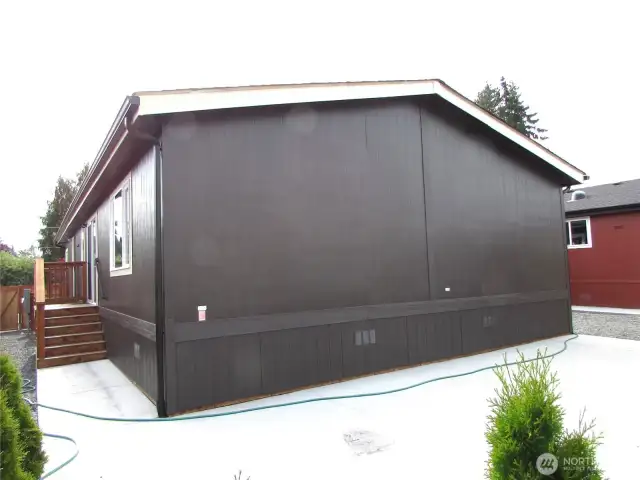 DECK W/ SLIDER TO LEFT GOES INTO DINING ROOM, OFF FAMILY ROOM/ KITCHEN AREA. NEW, TREE LINED CONCRETE PATIO FACES WEST.
