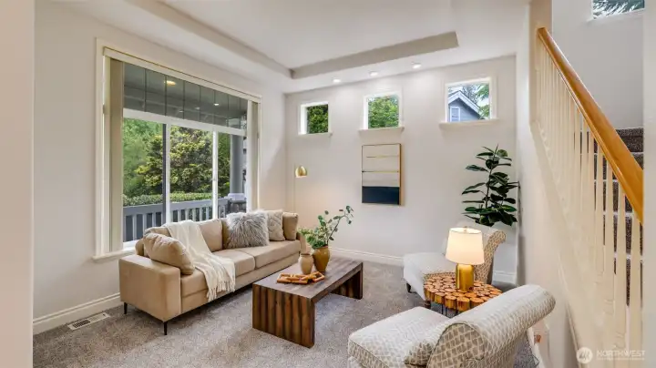 This formal living space is a great conversation room or place to curl up with a good book, with walls of windows and views to the manicured front yard.