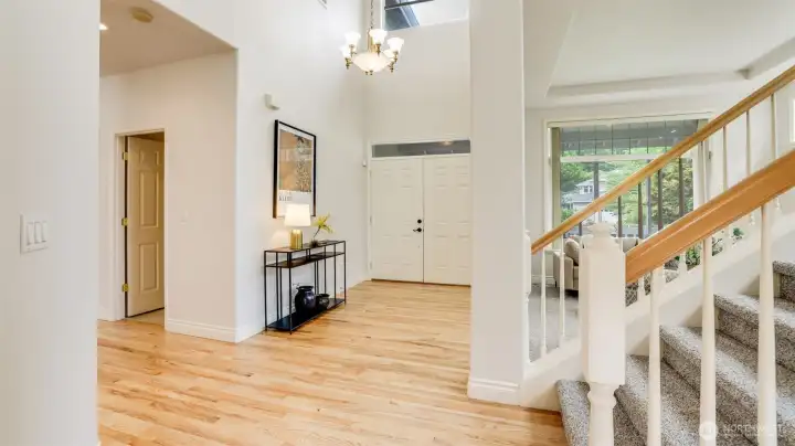 Grand high ceilings and a double-door entrance welcome you onto gleaming hardwood floors, with multiple windows flooding the space with natural light