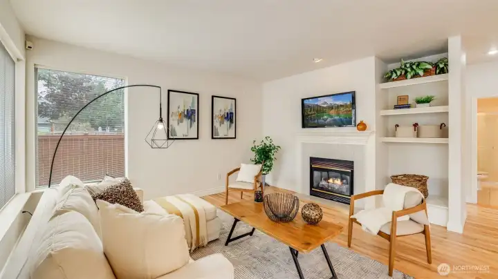 Spend cozy nights at home in this living room featuring built-in shelving, a gas fireplace and walls of windows bathing this space in natural light.
