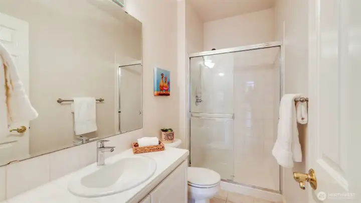 The 3/4 guest bathroom on the main floor features a walk-in shower, large mirrors, and generous space to accommodate all your bathroom necessities just steps from the main floor bedroom.