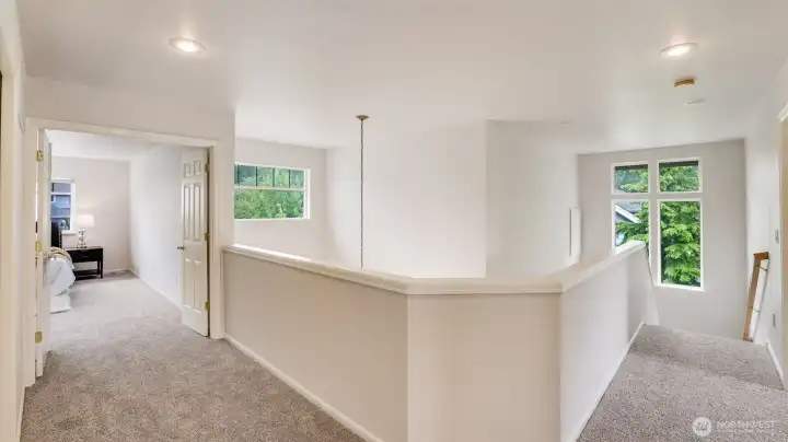 French doors open into the primary bedroom, which features a wide layout at the top of the stairs and soaring high ceilings