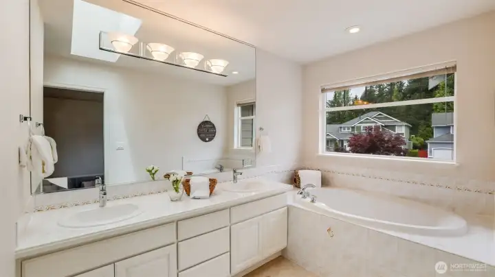 This sleek guest bathroom showcases a double vanity, abundant natural light, and a separate tub, all designed with clean white and natural tones for a fresh, modern feel