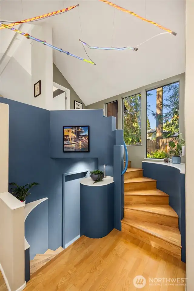 From the entry, a spiral staircase leads up to the lofted primary suite