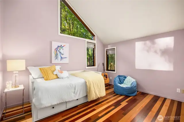 The secondary bedrooms share their own wing. Mixed species hardwood floors, vaulted ceilings, and amazing light are featured in bedroom #2.