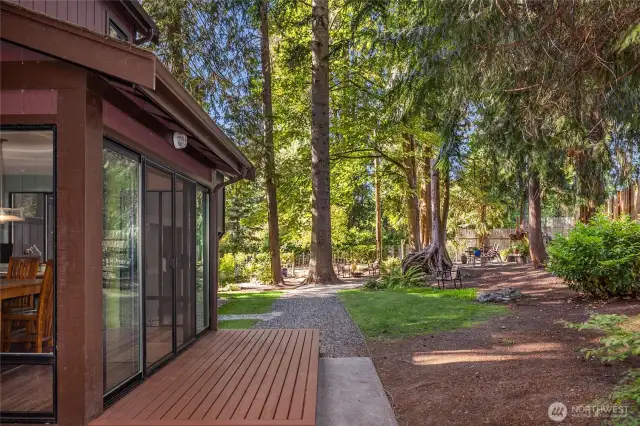 Downstairs, the deck outside the dining room leads to the peaceful, fenced backyard sanctuary
