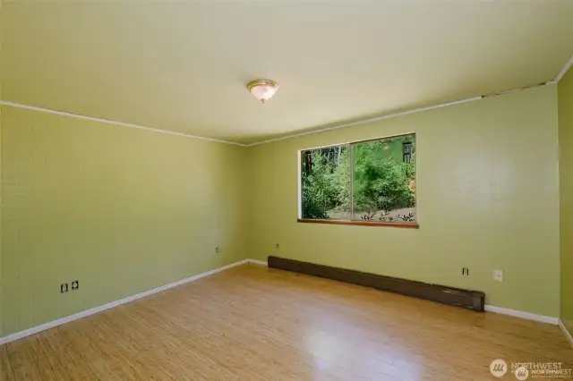 primary bedroom as paintable brick accent wall. Window overlooks lawn area. radiant baseboard mentioned before.