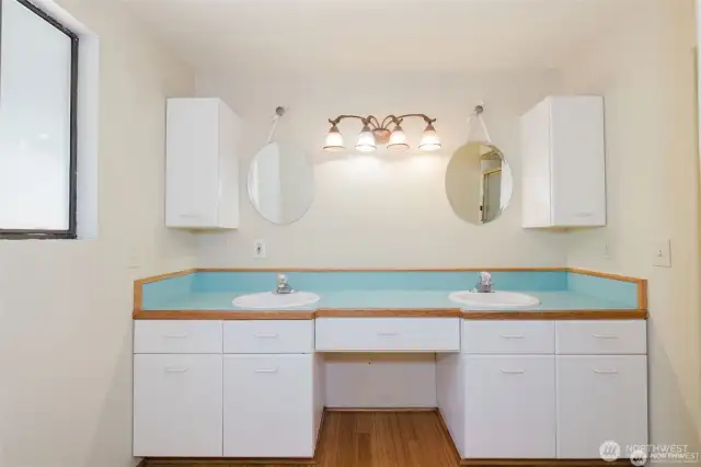 Double sink in ensuite bathroom with lots of storage and a seating area in vanity.