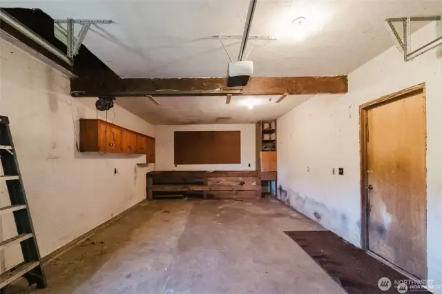 long garage with workbench and access to attic