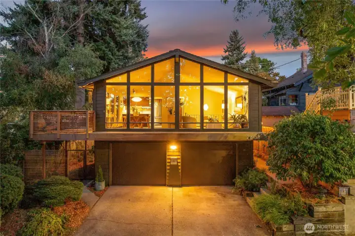 Chalet-inspired façade framed by heritage trees on a tranquil bend of 12th Avenue West, with soaring windows above a coveted 2-car garage and three additional off-street spaces.