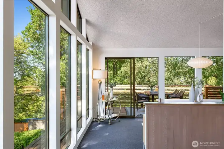 Glass walls and sliding doors create effortless flow from dining to lanai, blending indoor ease with treetop seclusion.”