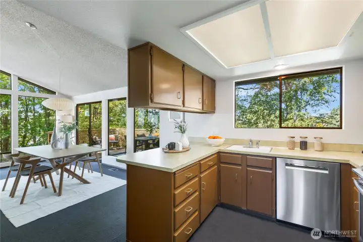 The spacious kitchen celebrates its original mid-century character, remarkably intact and undamaged—a rare find that many will treasure—while the floor plan also allows for easy future expansion to embrace even more of the views.