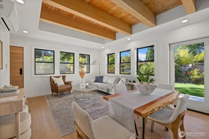 Spacious and bright living room with custom exposed-beam ceiling and beautiful hardwood flooring.