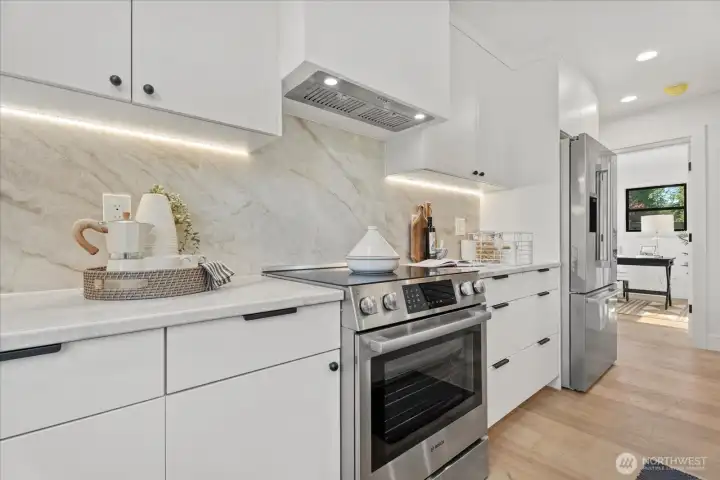 Kitchen with under-cabinet lighting and beautiful, full height quartzite stone backsplash.