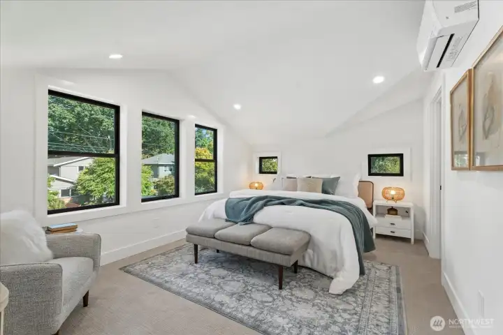 Primary bedroom with tons of natural lighting, elegant vaulted ceilings, and a large walk-in-closet.