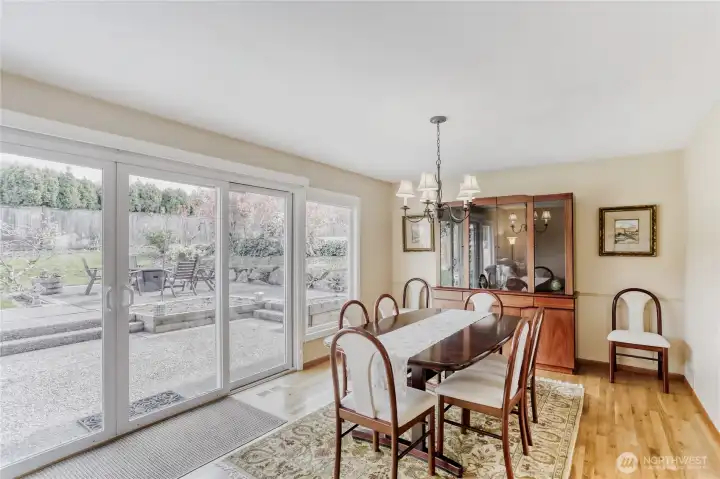 Formal dining room with a row of windows and access to the large patio and backyard, designed for memorable dinners.