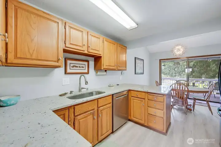 Who doesn't love a spacious kitchen with a lovely view? And a newer dishwasher, granite counters, wood cabinets and easy-to-maintain newer laminate wood floors!