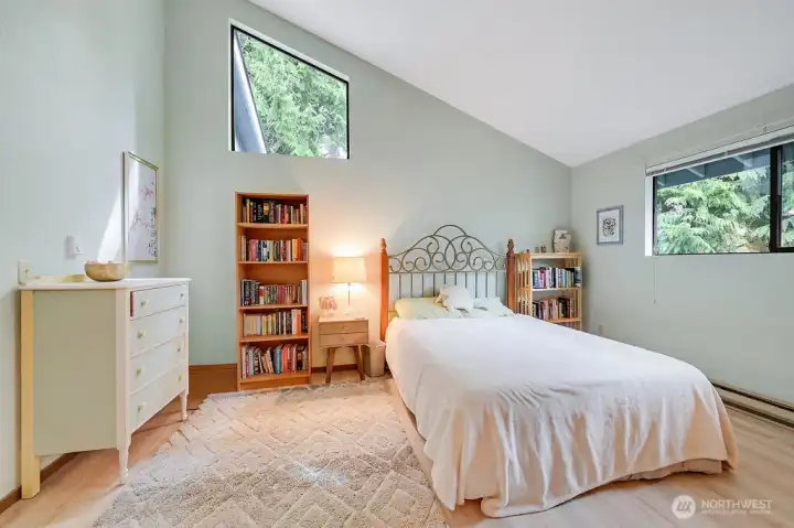 The roomy primary bedroom offers vaulted ceilings, natural light, newer floors, a walk-in closet & private bath.