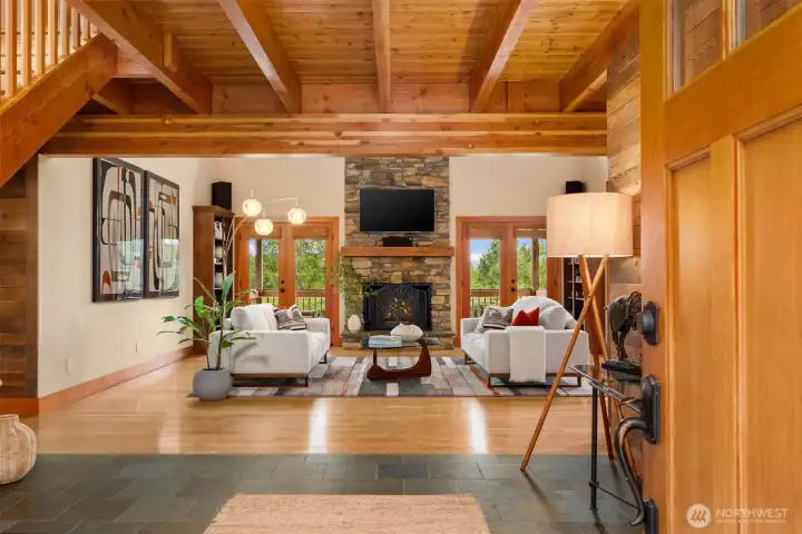 Welcome home! The large front entry with natural slate offers a practical place to dry-off (This is the PNW!) and serves as a cozy transition to the grander space beyond. Note the warmth of the exposed structural beams that are both beautiful and functional.
