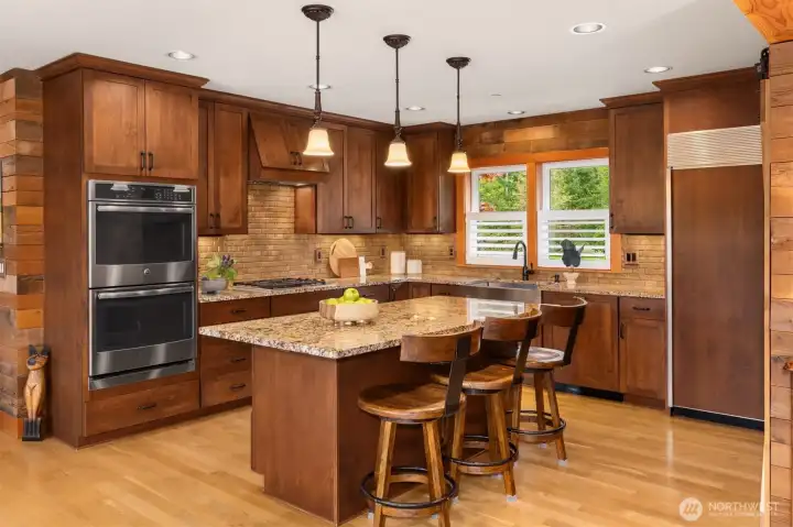 The functional design of the kitchen is a chef’s dream. The center island provides prep space, deep storage drawers, and seating for onlookers (with room for another stool at the near end). All cabinets are soft close, of course!