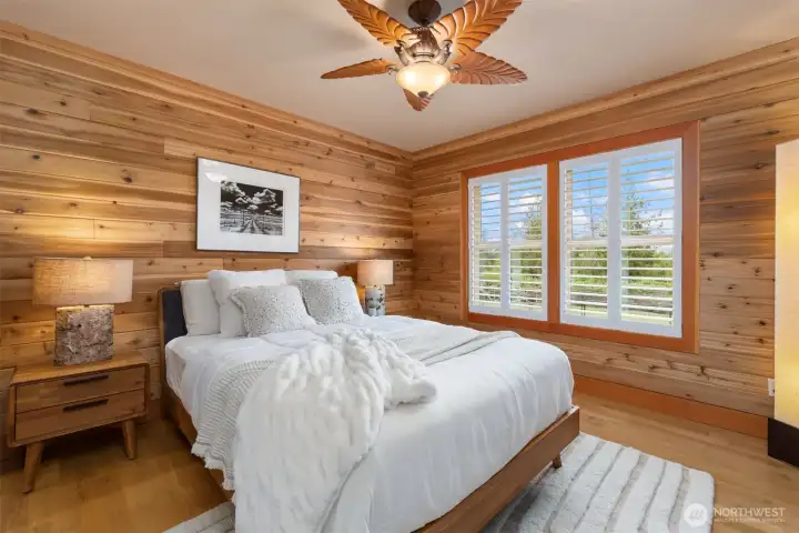 The 2nd bedroom is on the opposite side of the home from the primary bedroom. It is also an en suite, with its own 3/4 bath and a view of the verdant back yard.