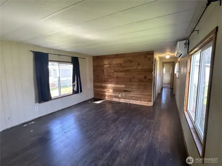 Another view of the living room with a cute accent wall. Hallway leads to bedrooms, bath, and laundry area.