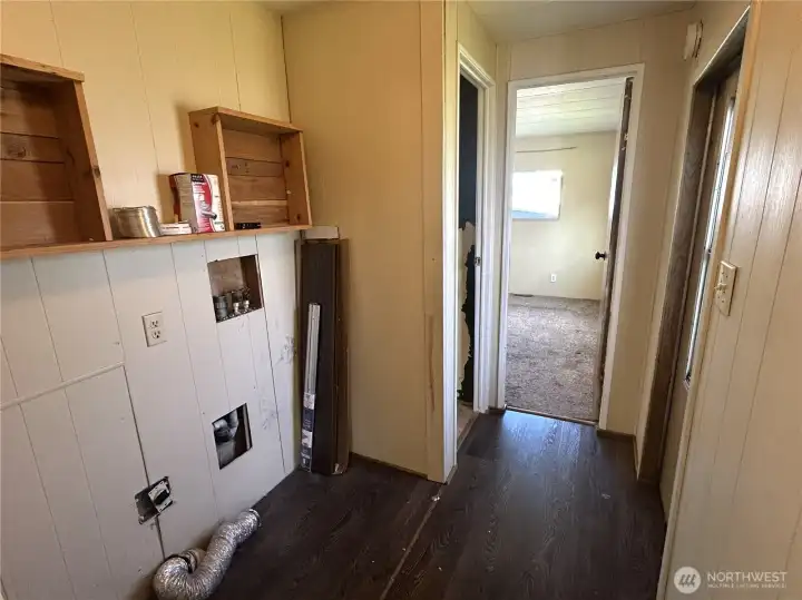 Laundry space. Primary bedroom is straight ahead, bathroom to the left, second bedroom is behind. Door to the right takes you outside.