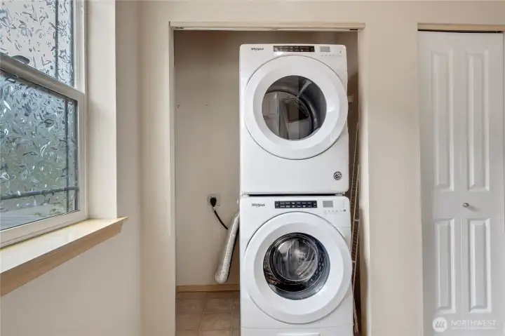 Convenient upstairs laundry with stackable washer and dryer, adding ease and efficiency to daily living.