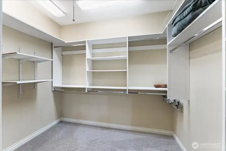 The spacious walk-in closet in the primary suite offers exceptional storage and organization featuring an abundance of built-ins to keep everything arranged.
