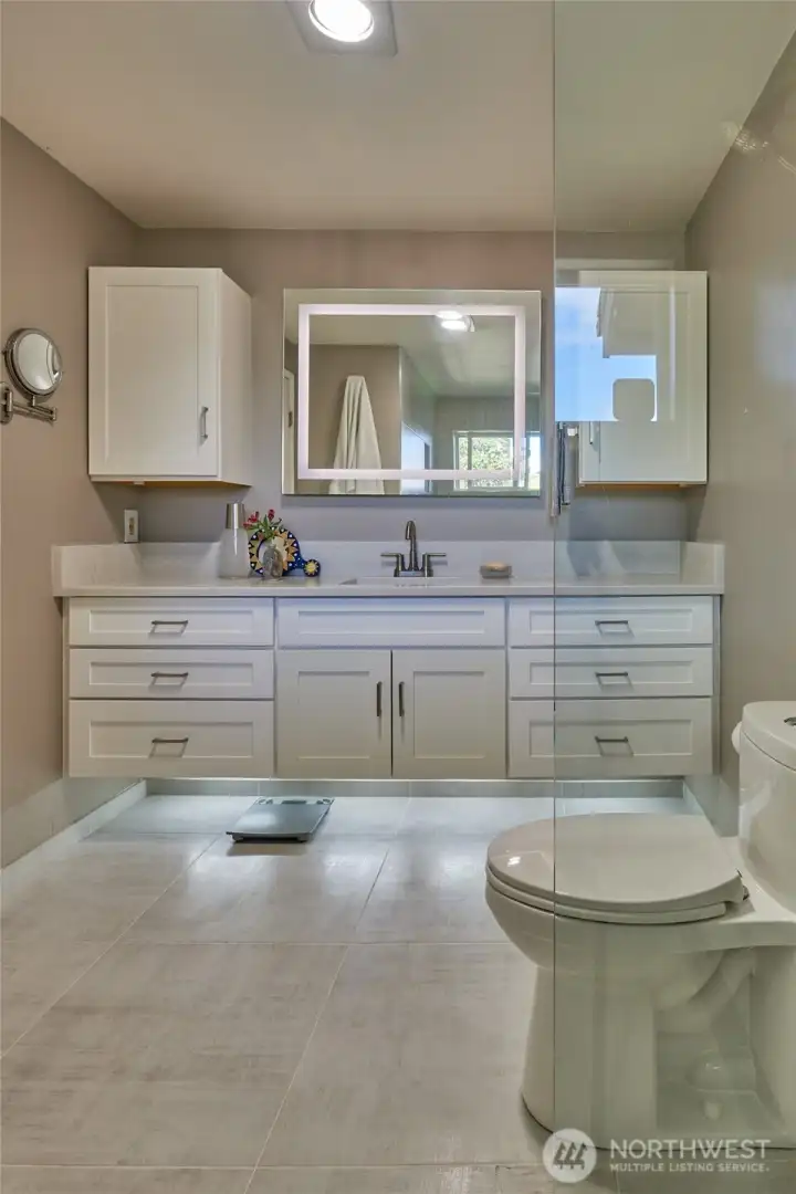 Enjoy the  luxurious primary bathroom with it's expansive shower and heated tile  floor