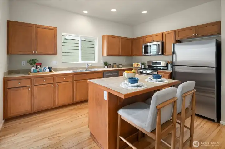 chef's kitchen with sleek stainless steel appliances, a center island, hardwood flooring