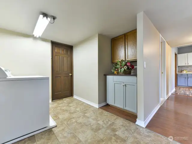 Laundry room has extra cupboards and/or folding table.