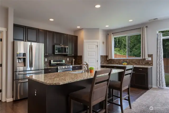 Functional kitchen with beautiful stainless appliances and walk in pantry.