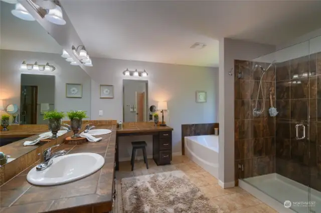 Primary in suite bathroom with walk in tile shower, soaking tub.
