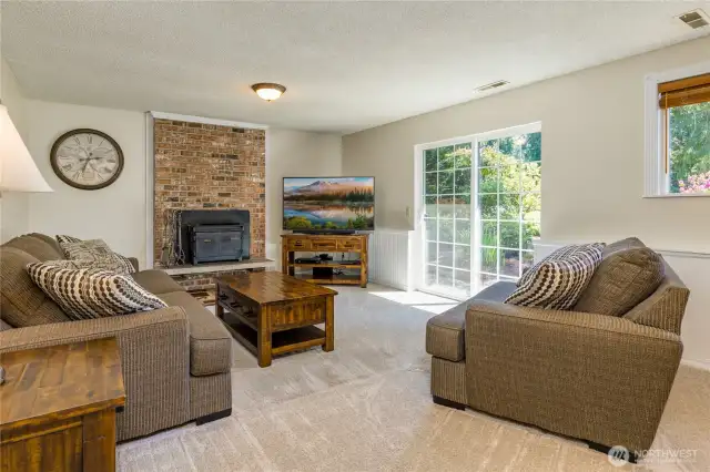 Family room on the lower level has a cozy wood fireplace insert